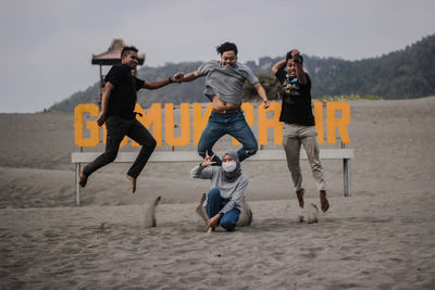 Happy friends jumping at beach