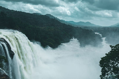 Scenic view of waterfall against sky