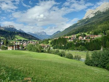 Scenic view of trees and houses against sky