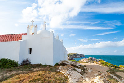 Lighthouse by sea against sky