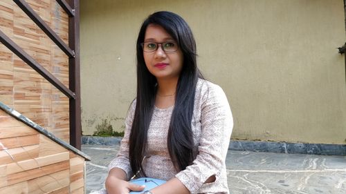 Portrait of beautiful young woman sitting outdoors