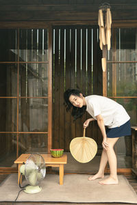 Side view of young woman sitting on table