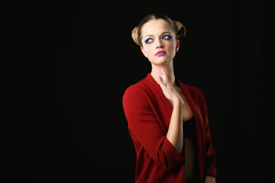 Portrait of woman against black background