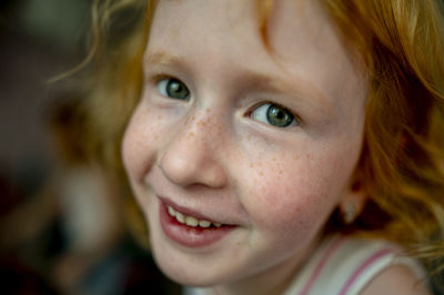 Smiling redhead girl with freckles on face