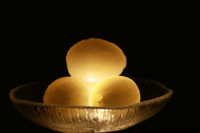 Close-up of illuminated candle against black background