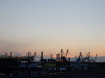 Commercial dock against clear sky during sunset