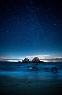 Scenic view of sea against star field at night