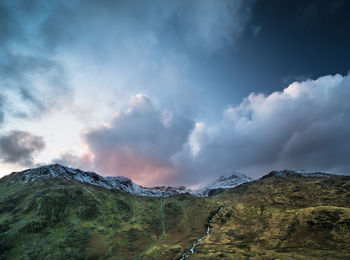 Low angle view of mountains against cloudy sky