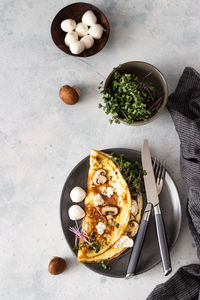 Classic egg omelette or omelet served with mushrooms, mozzarella and microgreens. breakfast. 