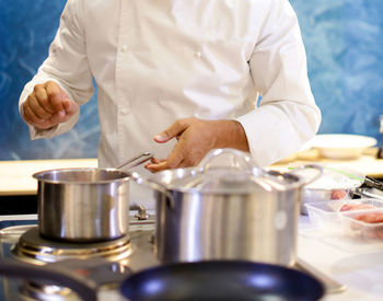 Midsection of man holding ice cream in kitchen