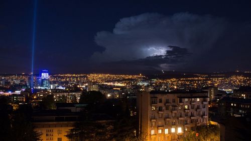 Illuminated cityscape against sky at night