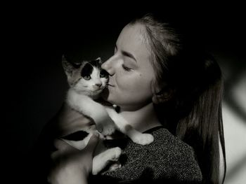 Close-up of young woman touching cat