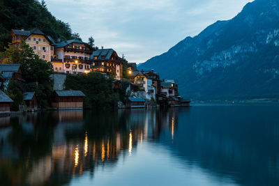 Scenic view of lake by buildings against sky