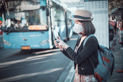 Woman standing on mobile phone in city