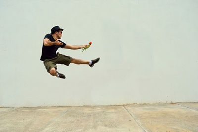 Young man jumping by wall