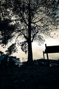Silhouette trees on field against sky