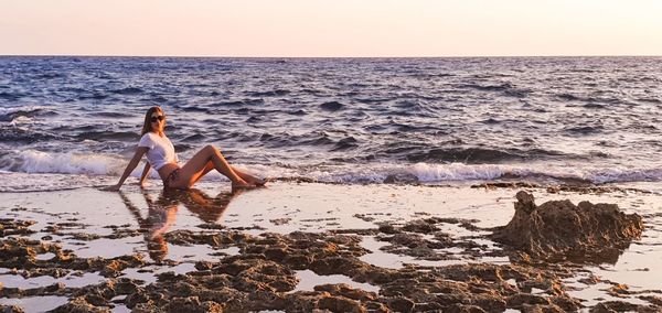 Woman on beach against sky