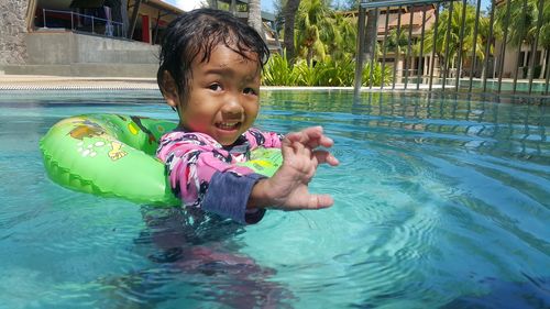 Girl swimming with inflatable ring in pool