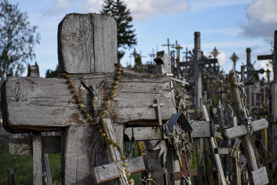 Wooden fence on cemetery against sky