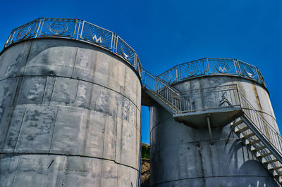 Low angle view of factory against blue sky