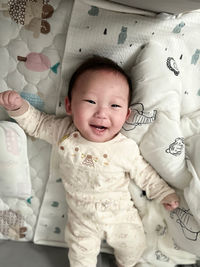 High angle view of cute baby boy sleeping on bed