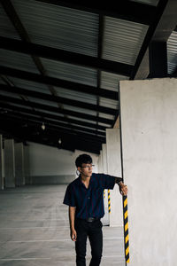 Young man standing in building corridor