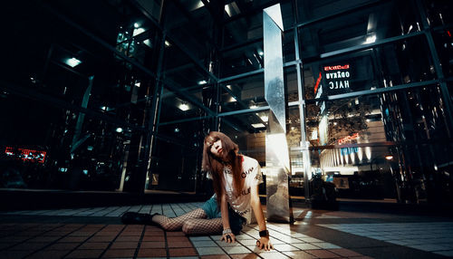 Portrait of young woman in city at night