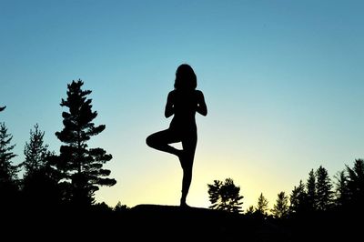Low angle view of silhouette trees against clear sky