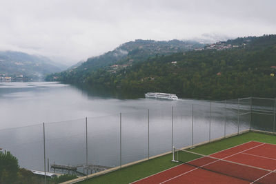 Scenic view of lake by mountains against sky