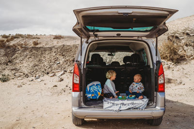 Kids having a picnic in the trunk of their car during vacation holiday
