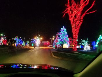 Illuminated car on road against sky at night