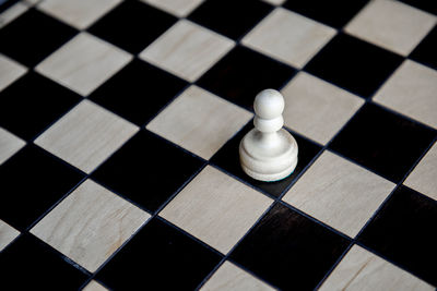 Close-up of chess pieces on tiled floor