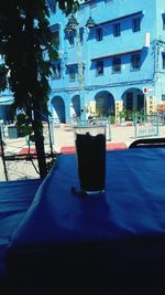 Tea light on table in city against blue sky