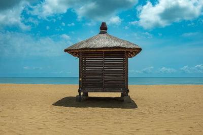 Lifeguard hut on beach against sky