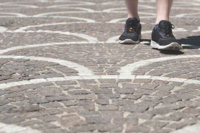 Low section of man on cobblestone road