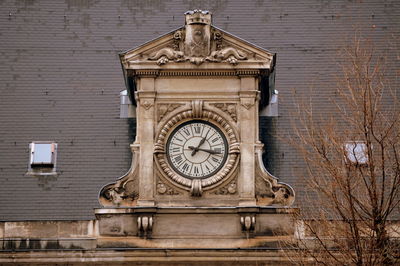 Low angle view of clock tower against old building