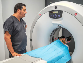 Side view of adult man operating mri scanner during pet examination in contemporary vet clinic