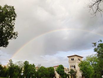 Low angle view of rainbow over building against sky
