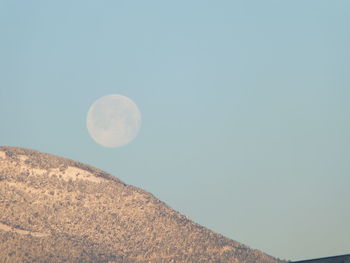 Low angle view of moon against clear blue sky