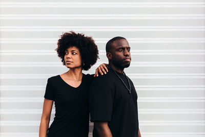 Black cool couple posing over white background looking at camera