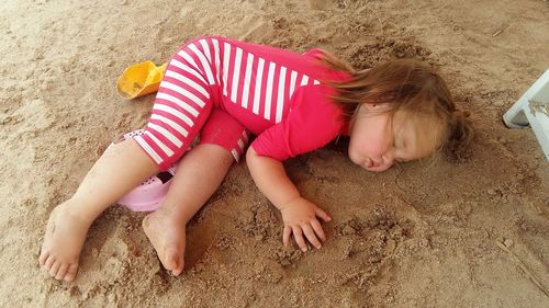 High angle view of girl sleeping at beach