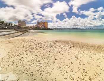 Beach coast lined with palm trees of distortion seaside and oak fashion buildings in okinawa.