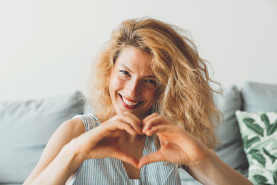 Portrait of young woman sitting on bed at home