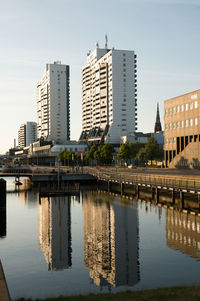 Reflection of buildings in city against sky