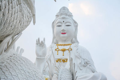 Low angle view of statue against temple against sky