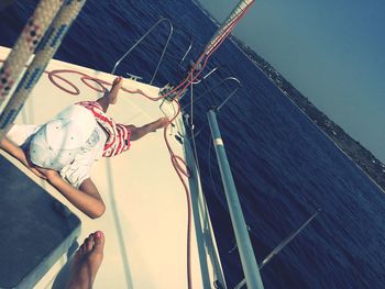 High angle view of woman standing by sea against sky