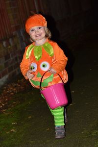 Portrait of girl wearing costume on footpath during halloween at night