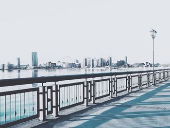 Pier by sea against sky in city