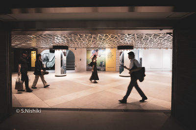 People walking in corridor of building