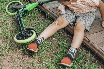 Brave little healer, child applying bandage to scrape, first lesson in self-care and first-aid.